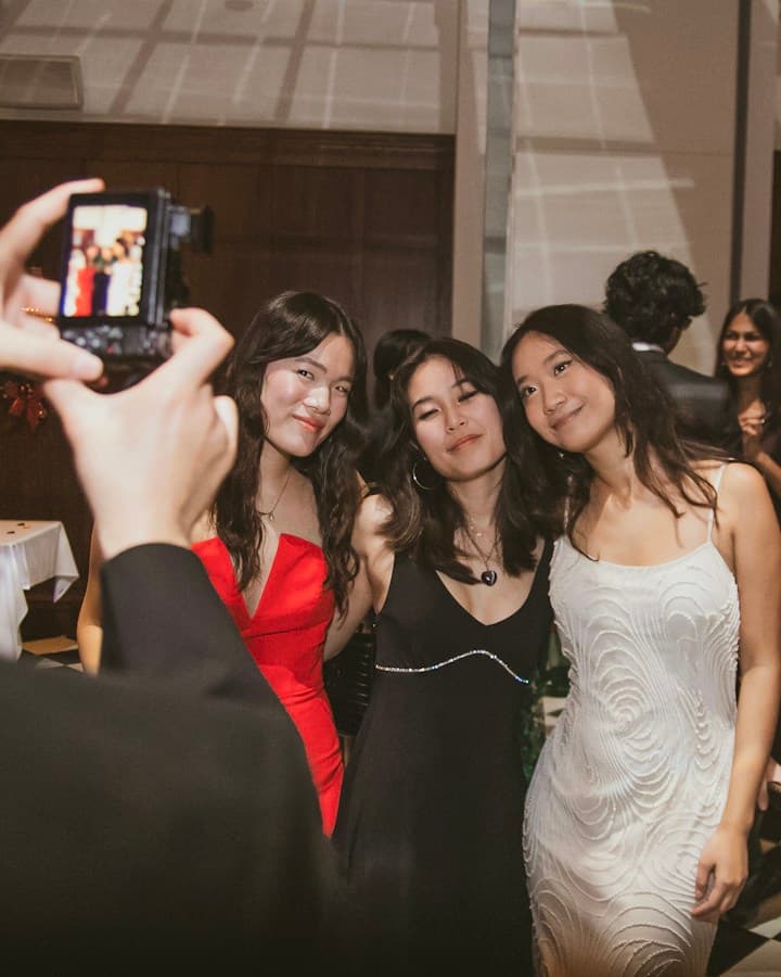 Convidado fotografa três amigas abraçadas na festa